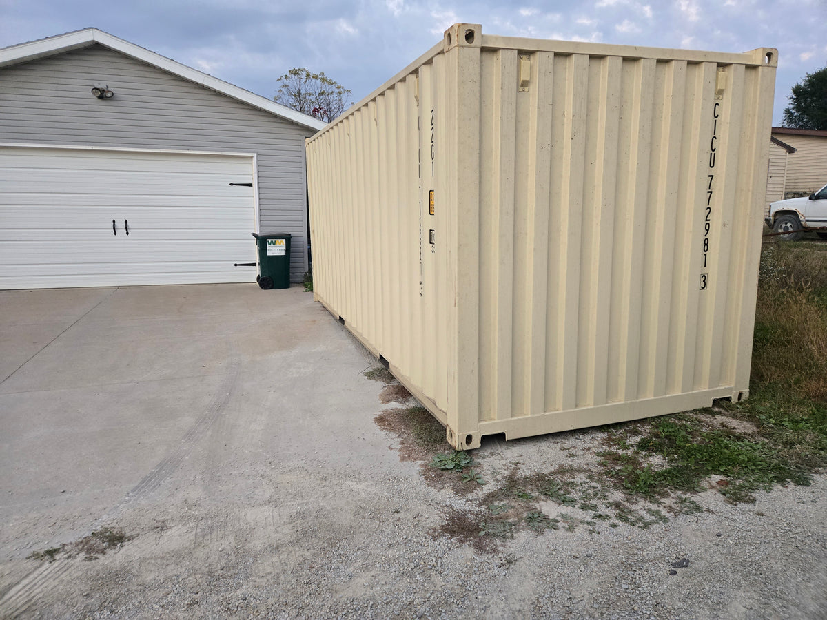 Beige storage container parked outside a building.