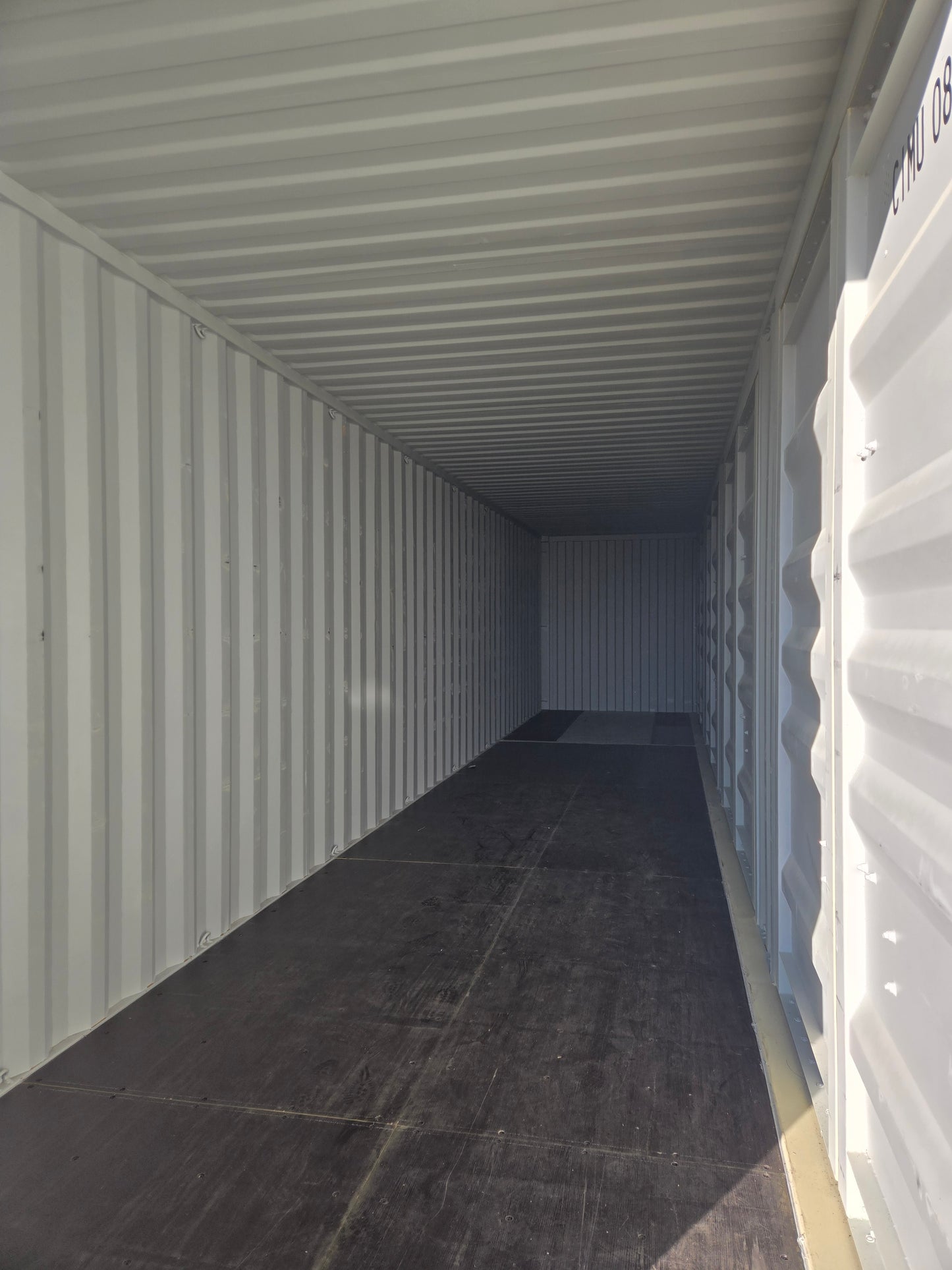 Empty storage container with corrugated metal walls and ceiling.